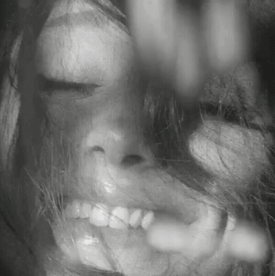 A Close Up Of A Woman 'S Face With Her Eyes Closed And Her Mouth Open . GIF