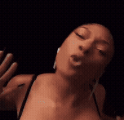 A Close Up Of A Woman 'S Face With Her Eyes Closed And Her Mouth Open In A Dark Room . GIF