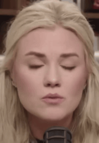 A Close Up Of A Woman 'S Face With Her Eyes Closed And Her Mouth Open . GIF