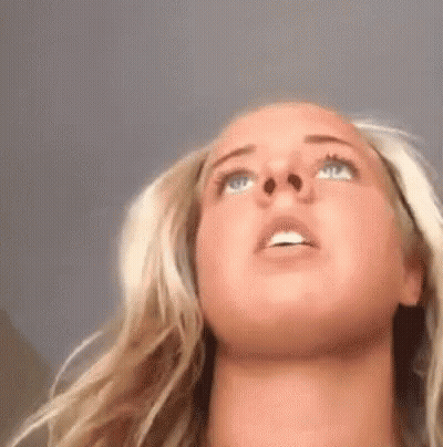 A Close Up Of A Woman 'S Face With Her Eyes Closed Looking Up . GIF