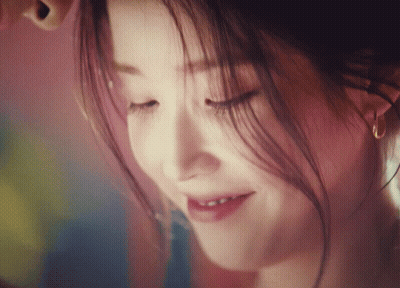 A Close Up Of A Woman 'S Face With Her Eyes Closed Smiling GIF