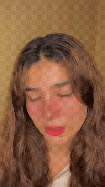 A Close Up Of A Woman 'S Face With Her Eyes Closed . GIF