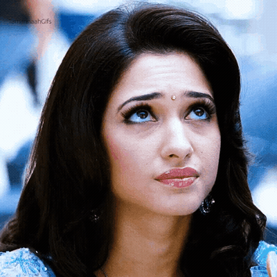 A Close Up Of A Woman 'S Face With Her Eyes Looking Up . GIF