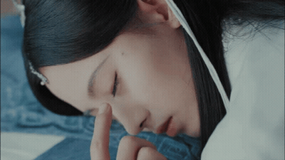 A Close Up Of A Woman 'S Face With Her Finger On Her Eye GIF