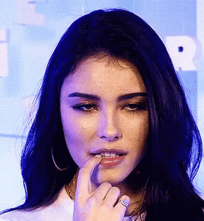 A Close Up Of A Woman 'S Face With Her Finger On Her Mouth GIF