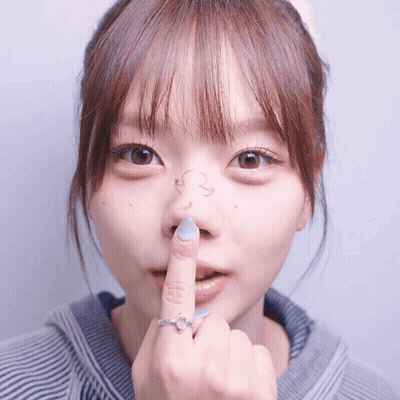 A Close Up Of A Woman 'S Face With Her Finger On Her Nose GIF
