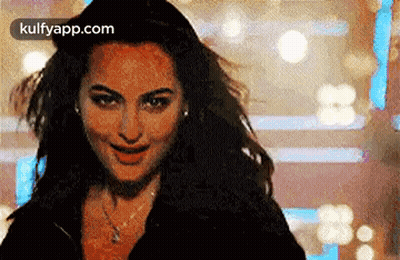 A Close Up Of A Woman 'S Face With Her Hair Blowing In The Wind And Smiling . GIF