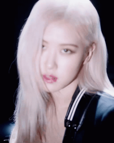 A Close Up Of A Woman 'S Face With Her Hair Blowing In The Wind GIF