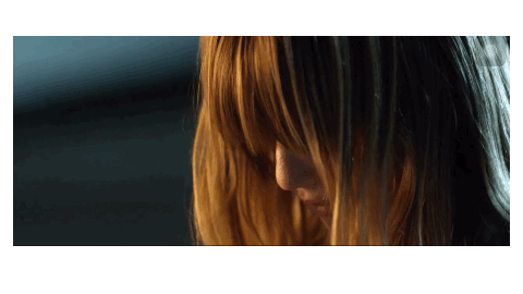 A Close Up Of A Woman 'S Face With Her Hair Covering Her Face GIF