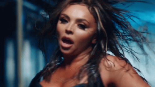 A Close Up Of A Woman 'S Face With Her Hair Flying In The Wind GIF