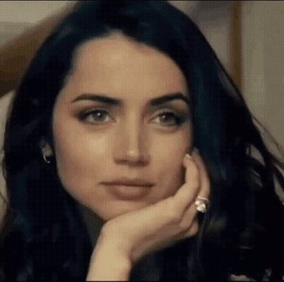 A Close Up Of A Woman 'S Face With Her Hand On Her Chin And A Diamond Ring On Her Finger . GIF
