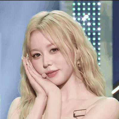 A Close Up Of A Woman 'S Face With Her Hand On Her Chin GIF