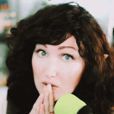 A Close Up Of A Woman 'S Face With Her Hand On Her Chin GIF