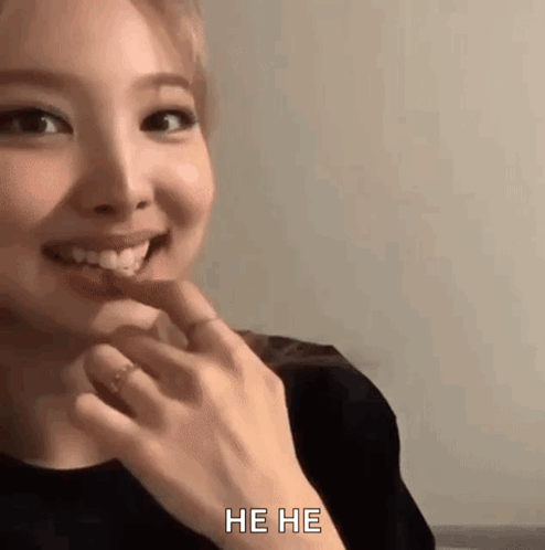 A Close Up Of A Woman 'S Face With Her Hand On Her Chin . GIF