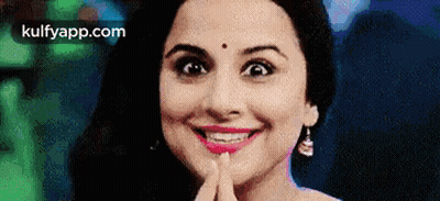 A Close Up Of A Woman 'S Face With Her Hand On Her Chin . GIF