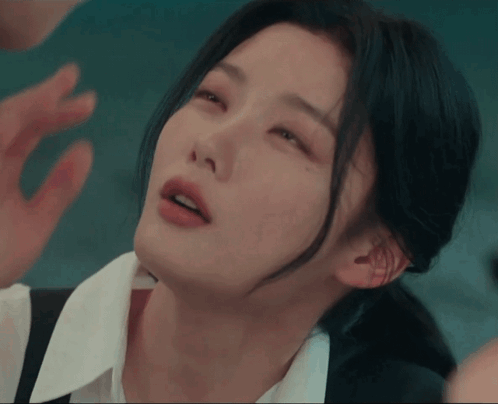 A Close Up Of A Woman 'S Face With Her Hand On Her Face GIF