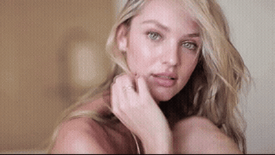 A Close Up Of A Woman 'S Face With Her Hand On Her Face And A Ring On Her Finger . GIF