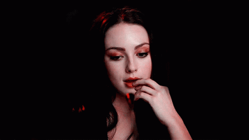 A Close Up Of A Woman 'S Face With Her Hand On Her Lips GIF