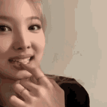 A Close Up Of A Woman 'S Face With Her Hand On Her Mouth . GIF