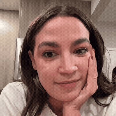 A Close Up Of A Woman 'S Face With Her Hand Resting On Her Chin GIF