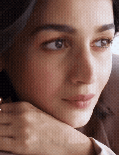 A Close Up Of A Woman 'S Face With Her Hand Under Her Chin GIF