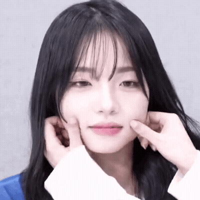 A Close Up Of A Woman 'S Face With Her Hands On Her Face . GIF