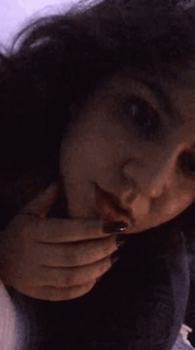 A Close Up Of A Woman 'S Face With Her Hands On Her Face . GIF