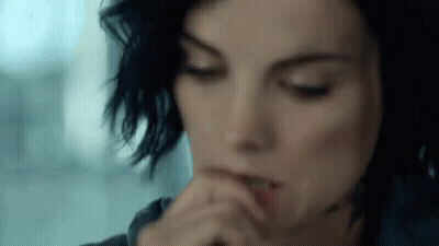 A Close Up Of A Woman 'S Face With Her Hands On Her Mouth . GIF