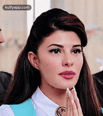 A Close Up Of A Woman 'S Face With Her Hands Together . GIF