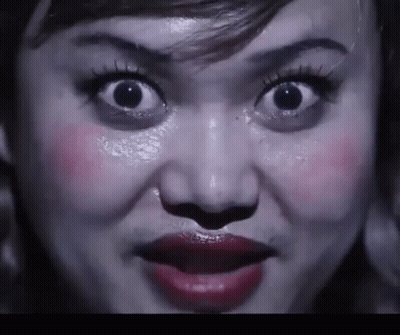 A Close Up Of A Woman 'S Face With Her Mouth Open GIF