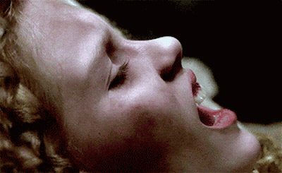 A Close Up Of A Woman 'S Face With Her Mouth Open GIF
