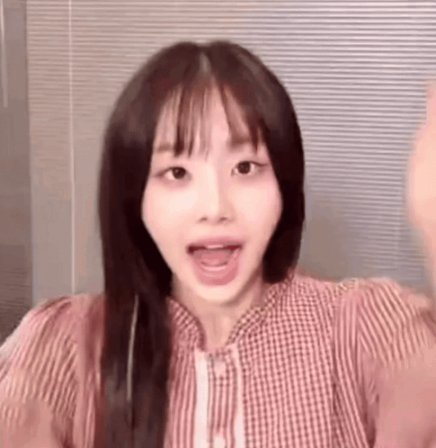 A Close Up Of A Woman 'S Face With Her Mouth Open And A Striped Shirt . GIF