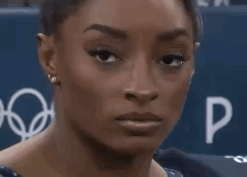 A Close Up Of A Woman 'S Face With Her Mouth Open And Earrings . GIF