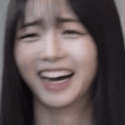 A Close Up Of A Woman 'S Face With Her Mouth Open And Her Eyes Closed . GIF
