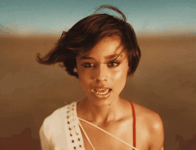 A Close Up Of A Woman 'S Face With Her Mouth Open And Her Hair Blowing In The Wind GIF