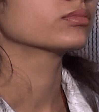 A Close Up Of A Woman 'S Face With Her Mouth Open And Her Neck Showing . GIF