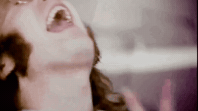 A Close Up Of A Woman 'S Face With Her Mouth Open GIF