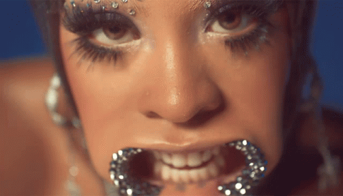 A Close Up Of A Woman 'S Face With Her Mouth Open GIF
