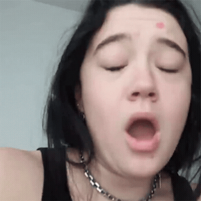 A Close Up Of A Woman 'S Face With Her Mouth Open . GIF