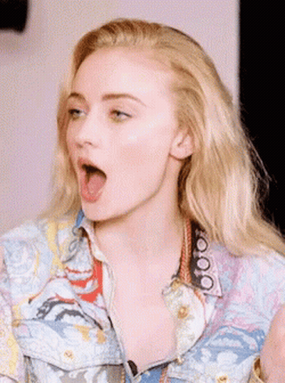 A Close Up Of A Woman 'S Face With Her Mouth Wide Open GIF