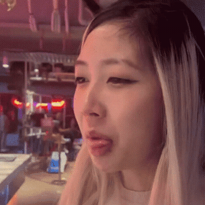 A Close Up Of A Woman 'S Face With Her Tongue Hanging Out . GIF