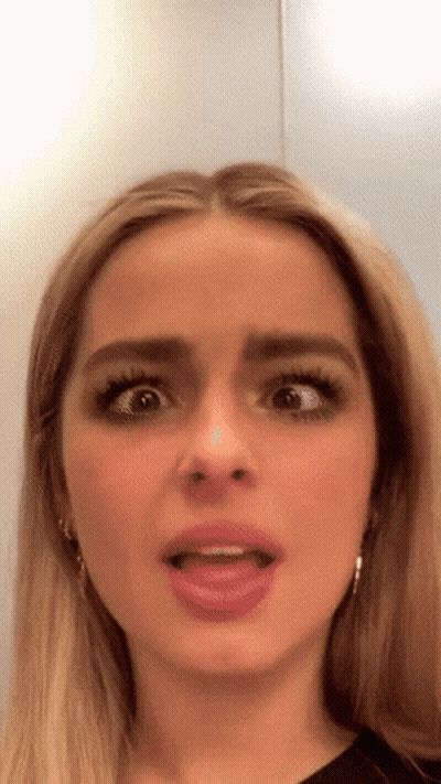 A Close Up Of A Woman 'S Face With Her Tongue Out GIF
