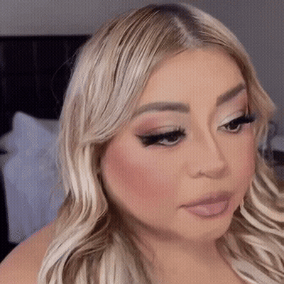 A Close Up Of A Woman 'S Face With Her Tongue Out GIF