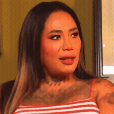 A Close Up Of A Woman 'S Face With Her Tongue Sticking Out GIF