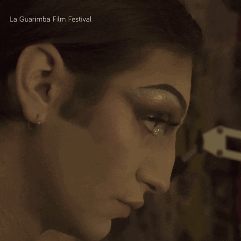 A Close Up Of A Woman 'S Face With La Guarimba Film Festival Written On The Bottom Right GIF