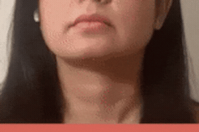 A Close Up Of A Woman 'S Face With Long Black Hair And Earrings . GIF