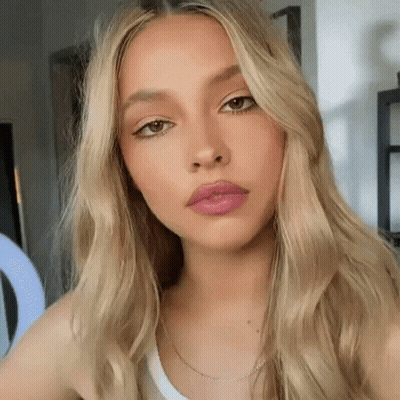 A Close Up Of A Woman 'S Face With Long Blonde Hair . GIF