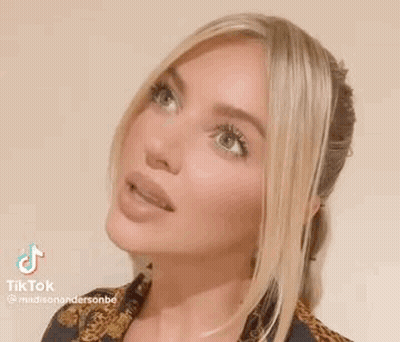 A Close Up Of A Woman 'S Face With Long Blonde Hair . GIF