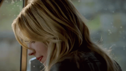 A Close Up Of A Woman 'S Face With Long Blonde Hair GIF
