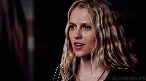 A Close Up Of A Woman 'S Face With Long Blonde Hair And Blue Eyes . GIF